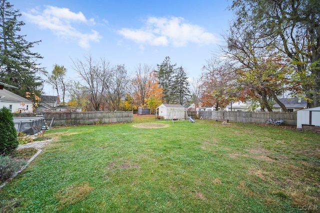 view of yard with a playground and a storage shed