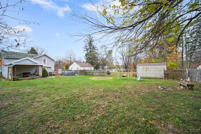 view of yard with a storage unit and a playground