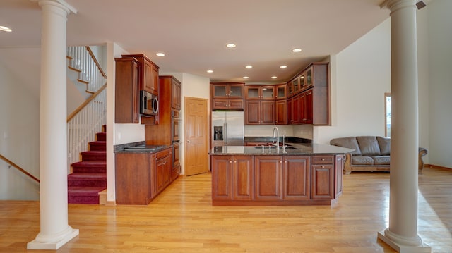 kitchen with light hardwood / wood-style floors, kitchen peninsula, sink, and appliances with stainless steel finishes