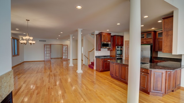 kitchen featuring stainless steel appliances, light hardwood / wood-style flooring, hanging light fixtures, and a notable chandelier