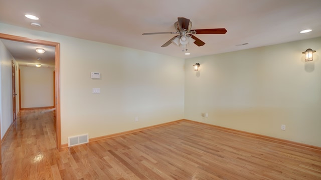 empty room with ceiling fan and light hardwood / wood-style flooring