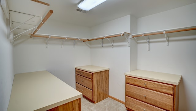 walk in closet featuring light colored carpet