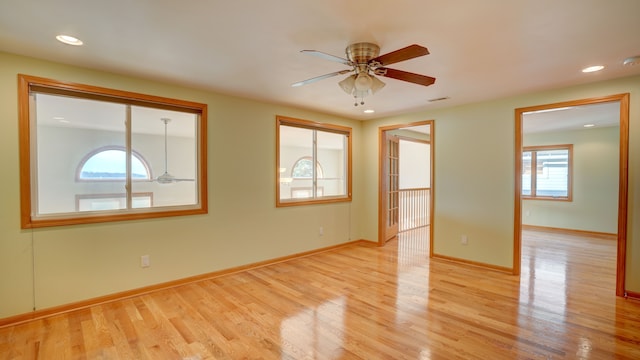 spare room with ceiling fan, plenty of natural light, and light hardwood / wood-style floors