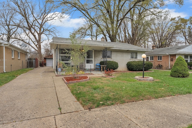 view of front of house featuring a garage, an outbuilding, and a front lawn