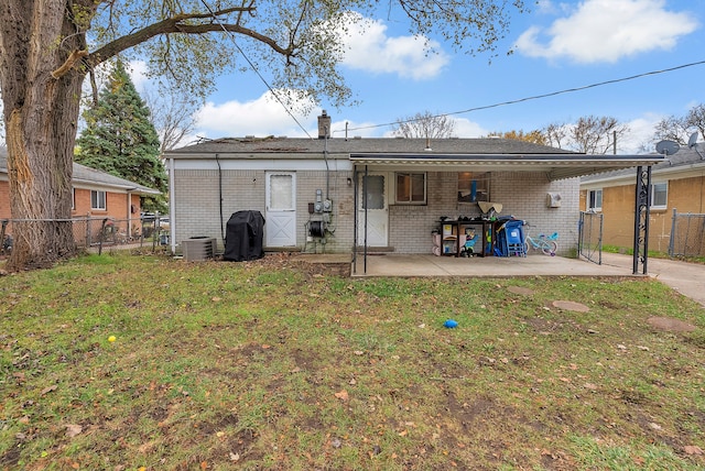 rear view of house featuring central air condition unit, a yard, and a patio