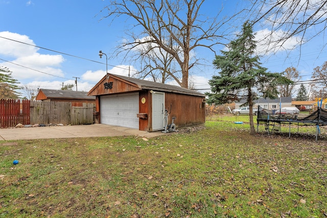 exterior space with an outbuilding, a trampoline, and a garage