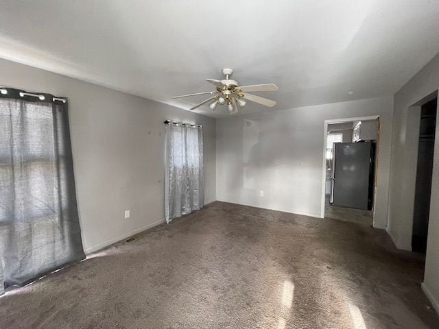 carpeted empty room featuring ceiling fan