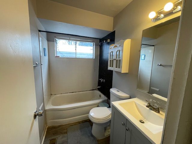 full bathroom featuring vanity, toilet, and tiled shower / bath