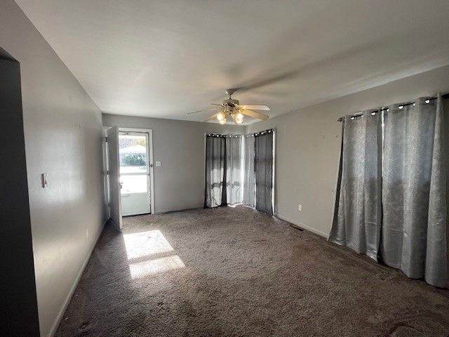 carpeted empty room featuring ceiling fan