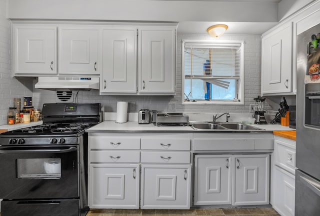 kitchen with decorative backsplash, black range with gas cooktop, sink, white cabinets, and range hood