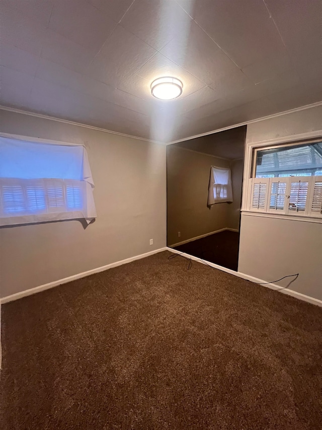 carpeted empty room featuring crown molding