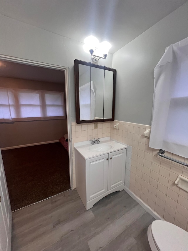 bathroom with vanity, hardwood / wood-style flooring, toilet, and tile walls