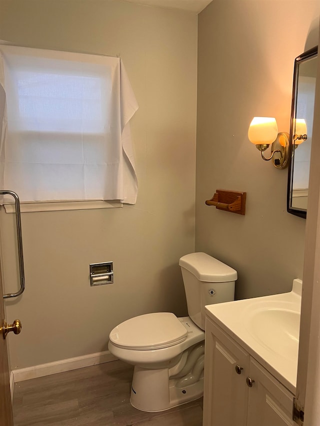 bathroom featuring vanity, hardwood / wood-style flooring, and toilet