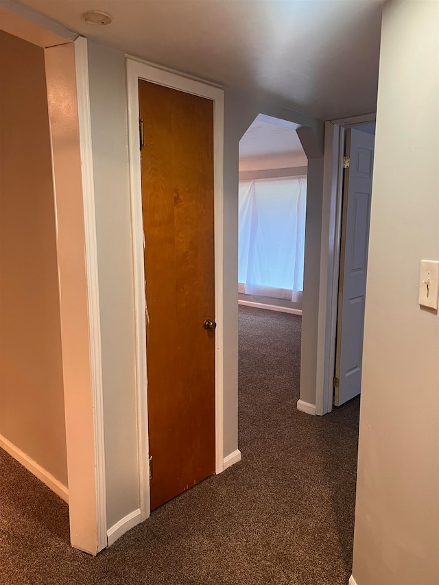 hall featuring dark colored carpet