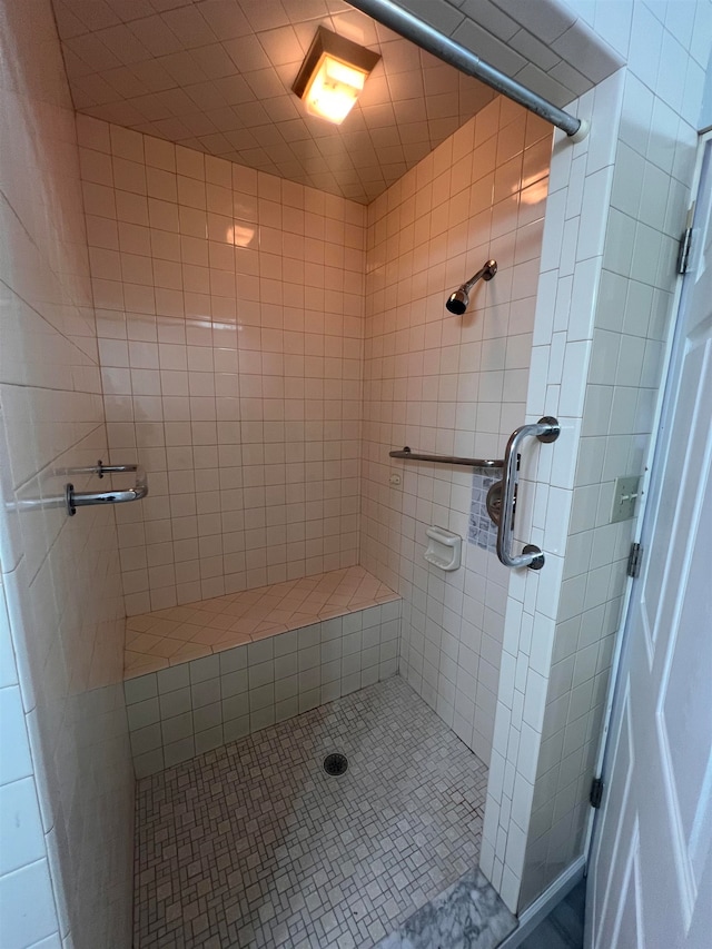 bathroom with a tile shower and tile patterned flooring