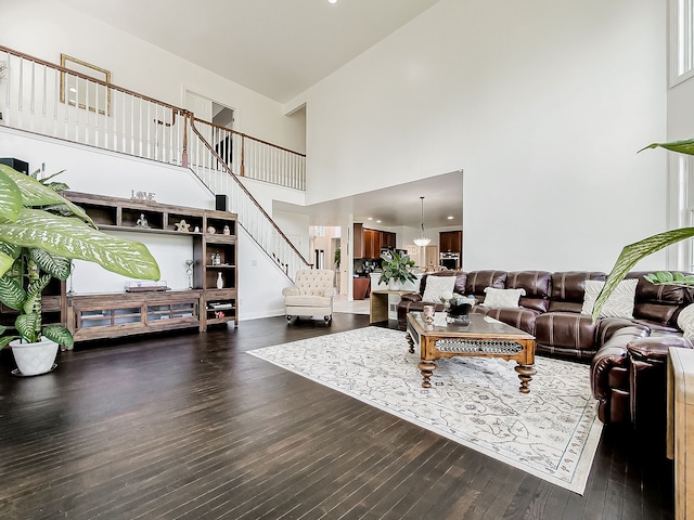 living room featuring dark hardwood / wood-style flooring and a towering ceiling