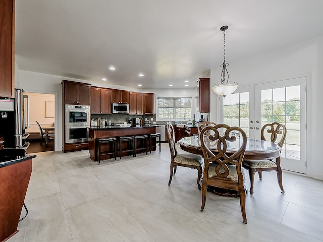 dining space with french doors and light tile patterned floors