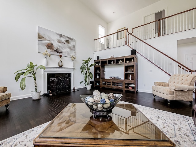 living room with dark hardwood / wood-style floors and high vaulted ceiling