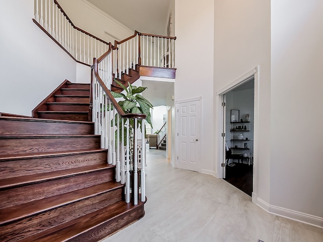 stairway featuring a towering ceiling