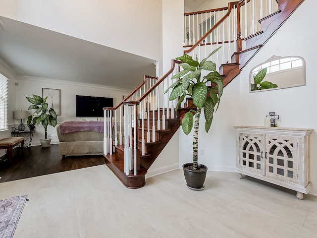 staircase featuring ornamental molding and hardwood / wood-style flooring