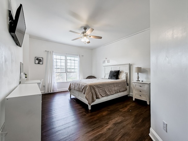 bedroom with dark hardwood / wood-style flooring, ceiling fan, and ornamental molding