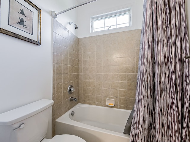 bathroom featuring shower / tub combo and toilet