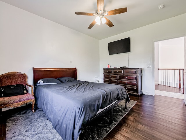 bedroom with dark hardwood / wood-style flooring and ceiling fan