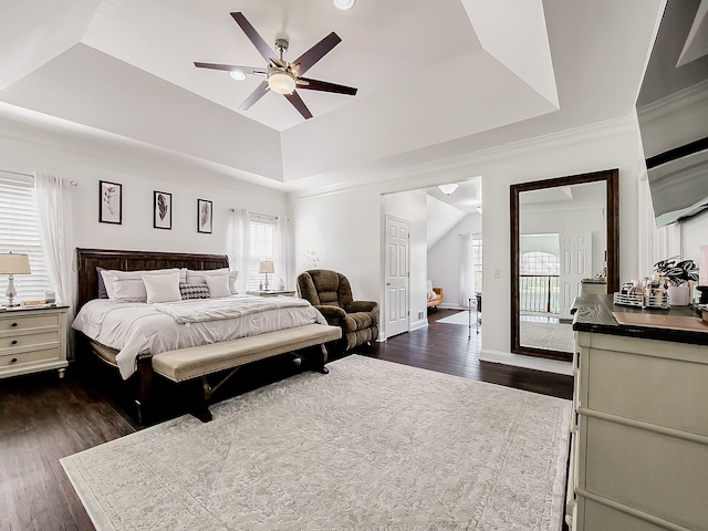 bedroom with access to outside, dark hardwood / wood-style floors, ceiling fan, and a tray ceiling