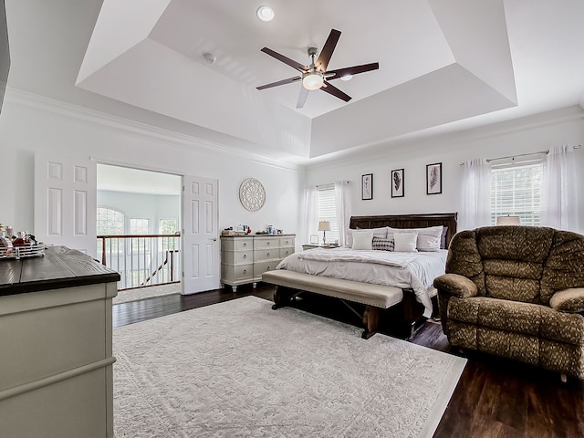 bedroom featuring dark hardwood / wood-style floors, ceiling fan, a raised ceiling, and access to outside