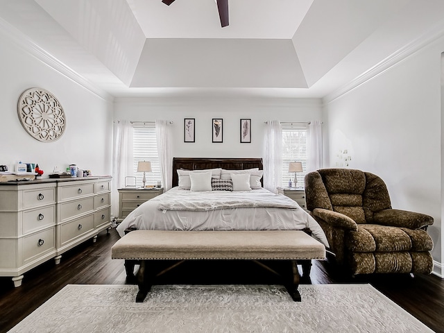 bedroom with dark hardwood / wood-style flooring, a raised ceiling, ceiling fan, and crown molding