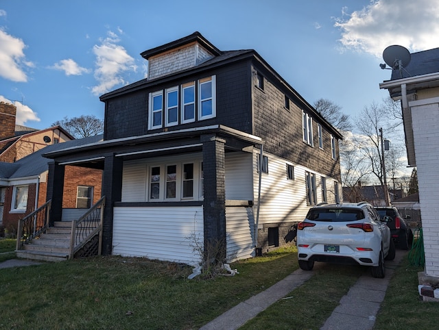 view of front of house featuring covered porch and a front yard