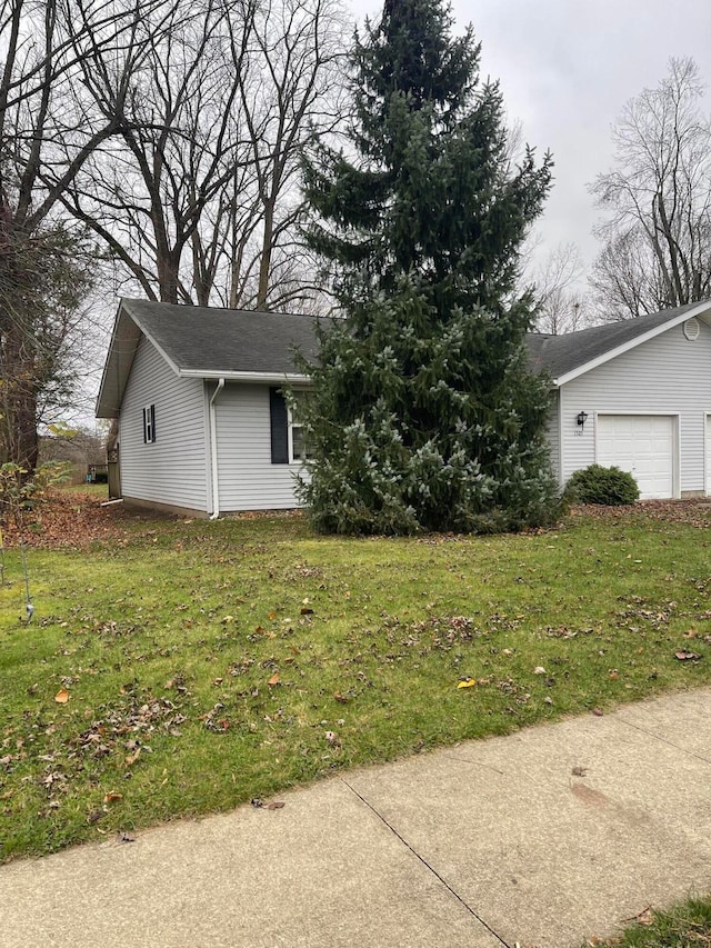 view of side of home featuring a yard and a garage