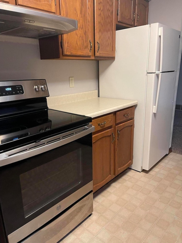 kitchen featuring white refrigerator, extractor fan, and stainless steel range with electric cooktop