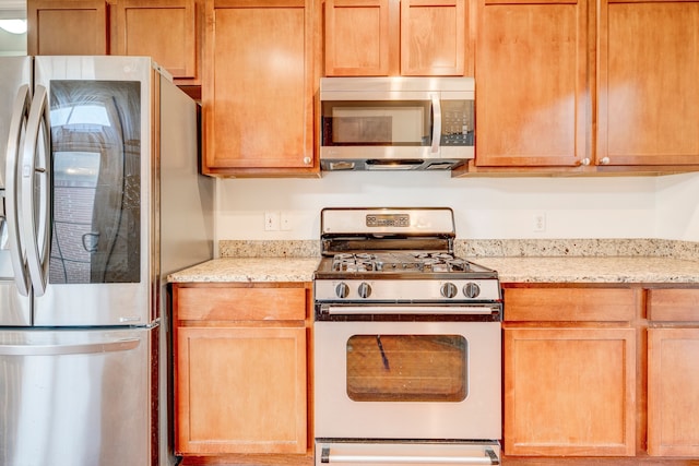 kitchen with light stone counters and stainless steel appliances