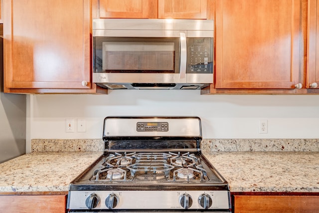 kitchen featuring light stone countertops and stainless steel appliances