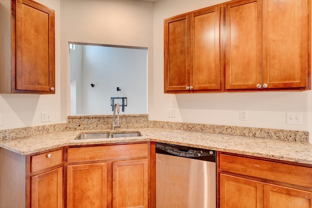 kitchen with light stone countertops, dishwasher, and sink