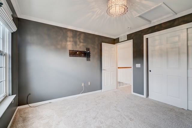 unfurnished bedroom featuring carpet floors, crown molding, and an inviting chandelier