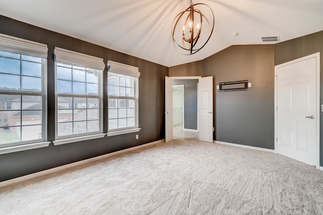 unfurnished bedroom featuring a chandelier, carpet flooring, and lofted ceiling