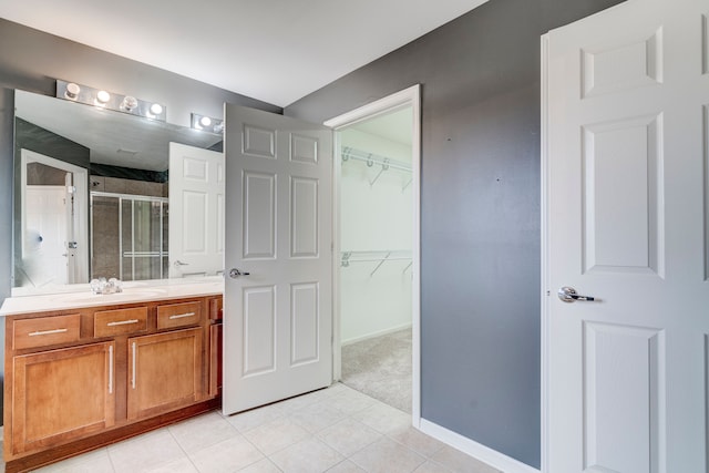 bathroom featuring tile patterned flooring, vanity, and a shower with door