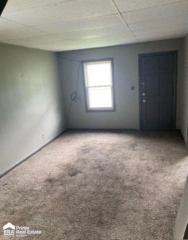 unfurnished room featuring carpet floors and a paneled ceiling