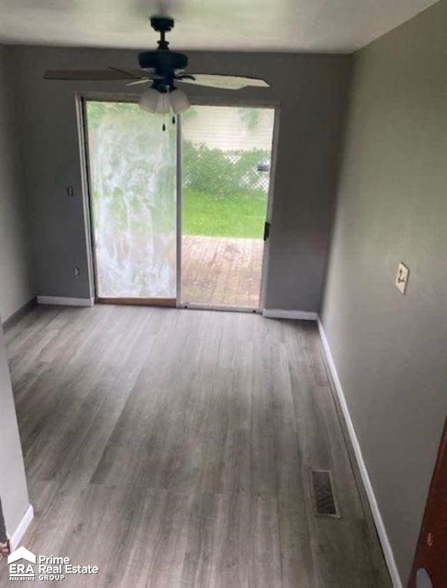 unfurnished room with hardwood / wood-style floors, ceiling fan, and a healthy amount of sunlight