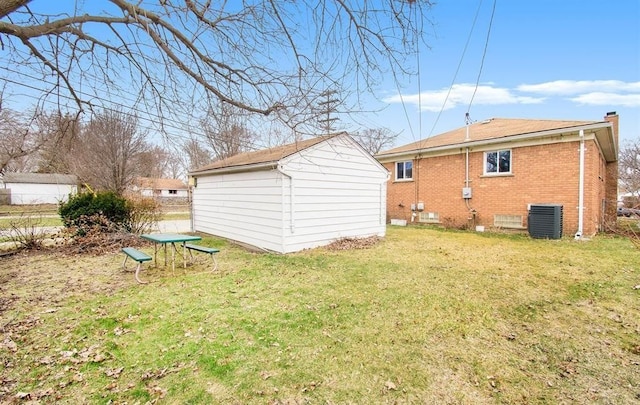 back of property featuring a lawn, central air condition unit, and a storage shed