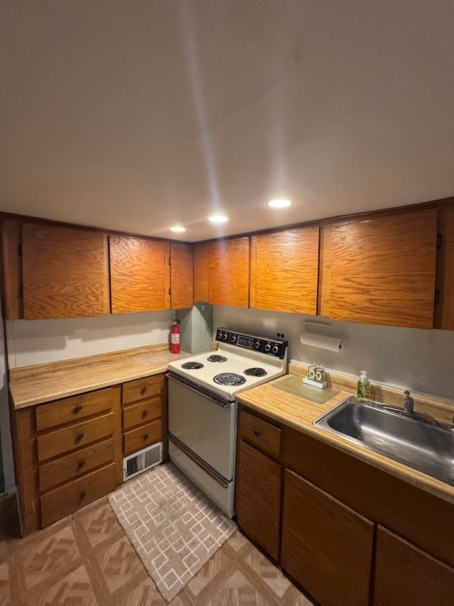 kitchen with white range with electric cooktop and sink