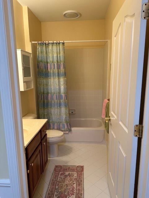 full bathroom featuring tile patterned floors, shower / bath combo with shower curtain, vanity, and toilet