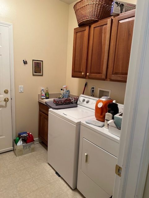 laundry room featuring cabinets and washing machine and clothes dryer