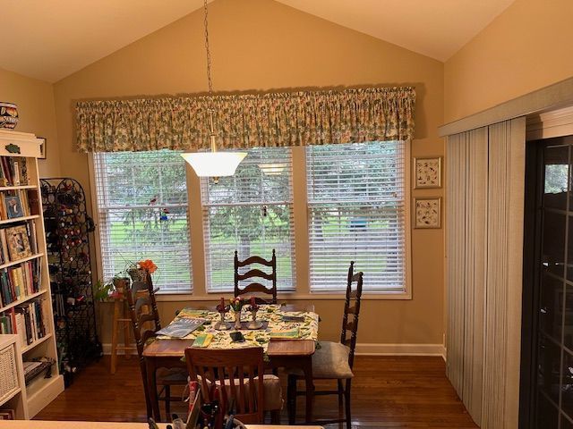 dining room with a wealth of natural light, dark hardwood / wood-style flooring, and lofted ceiling