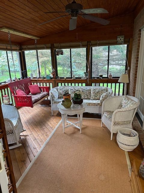 sunroom / solarium featuring plenty of natural light, wooden ceiling, and ceiling fan