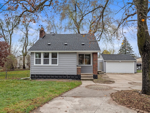 view of front facade featuring a garage, an outbuilding, and a front yard