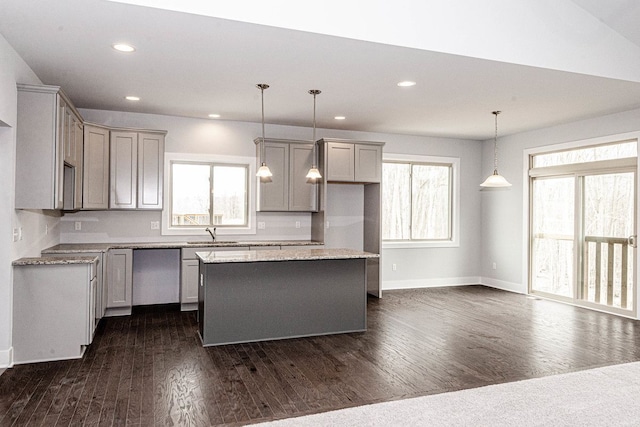 kitchen featuring dark hardwood / wood-style flooring, sink, pendant lighting, gray cabinets, and a kitchen island