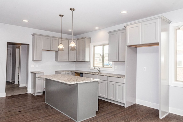 kitchen with dark hardwood / wood-style flooring, gray cabinets, a center island, and decorative light fixtures